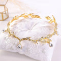 A delicate golden crown headband wedding featuring clear crystals and teardrop pendants for elegant headband wedding headdress