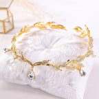 A delicate golden crown headband wedding featuring clear crystals and teardrop pendants for elegant headband wedding headdress
