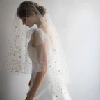 A golden shiny big veil made of white sheer fabric adorned with delicate star-shaped embellishments