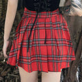 Gothic pleated short red plaid skirt with black and white stripes, gathered waistband, leather straps, and metal hardware