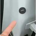 Black circular gps car tracker button with white lettering featuring dual microphone recording functionality