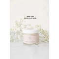 A clear glass jar with white lid and pale pink label containing beige clay facial mask in grapefruit body scrub wine glass spa gift basket