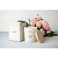 White cylindrical scented candle with natural wood lid labeled green lemon made of natural soy wax in spa gift basket