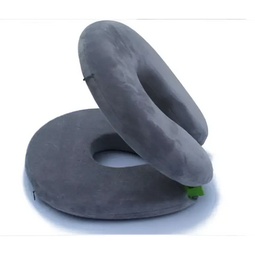Gray foldable travel pillow with plush cushioned texture and circular design featuring green fabric accents