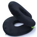 Black plush foldable travel pillow with green fabric accents and zipper pull featuring a circular gray design