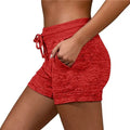 Red heathered athletic shorts with drawstring waistband and side pockets made from stretch sports fabric for women