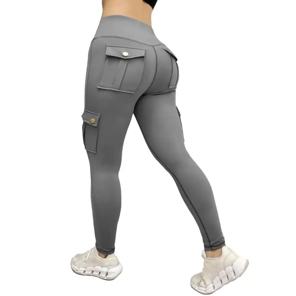 Gray high waisted cargo leggings with multiple pockets and gold-tone button closures featuring functional design making