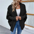 Black loose knitted sweater with ribbed cuffs and a solid color cardigan design in a comfortable open front style