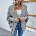 Gray loose knitted sweater with solid color cardigan design featuring ribbed cuffs and an open front style