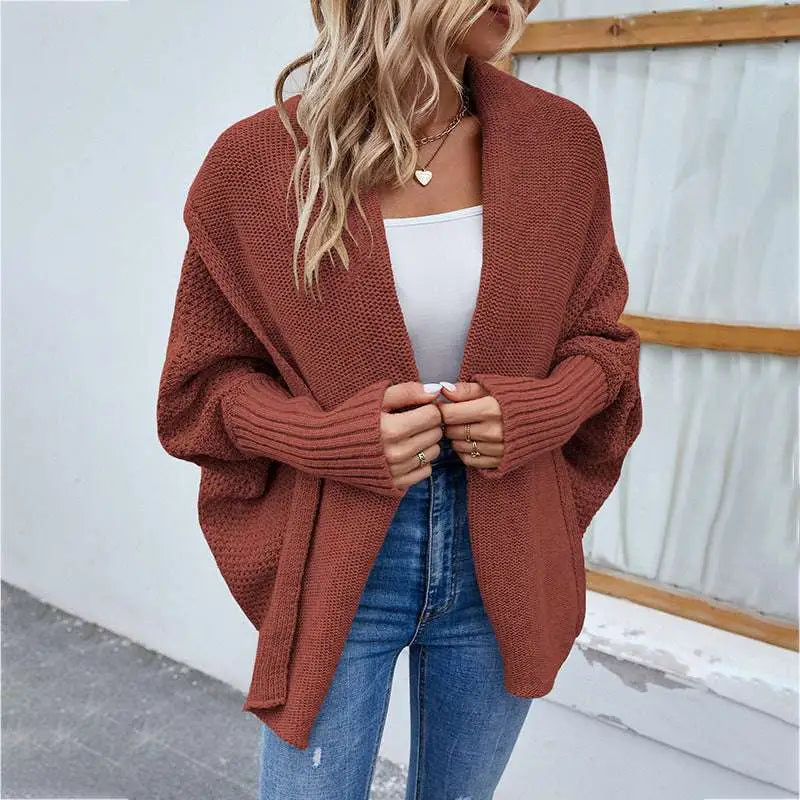 A cozy rust-colored loose knitted sweater solid color cardigan with a relaxed open-front design and ribbed cuffs
