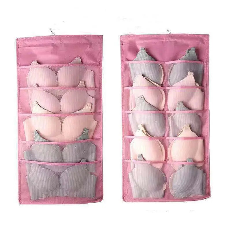 Pink fabric bra organizer with multiple compartments holding colorful bras inside a gray mesh bra hanging storage bag
