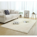 Cream-colored plush faux fur area rug with silky fluffy carpet texture and slightly irregular edges for modern home decor