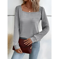 A maroon faux leather clutch with flap closure and gold-tone hardware paired with a gray solid color square neck versatile long sleeved top