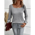 A soft gray solid color long sleeved top with a square neck versatile design and slightly puffed sleeves