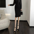 Black satin midi dress with long sheer sleeves and fitted silhouette paired with a gray textured line sheath skirt