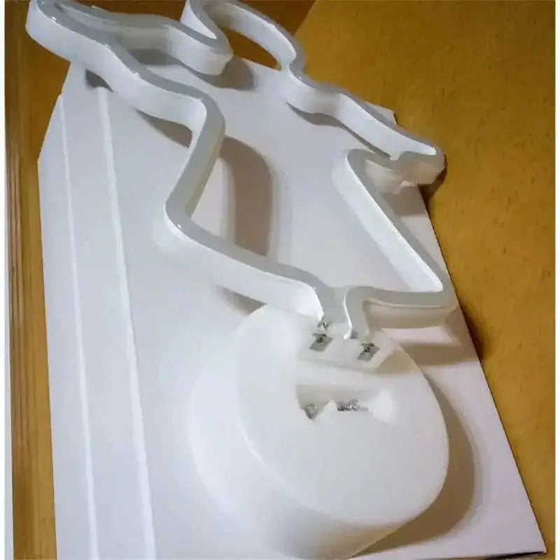 White led neon lights shaped like a stylized angel with glowing edges on a circular base for perfect ambiance