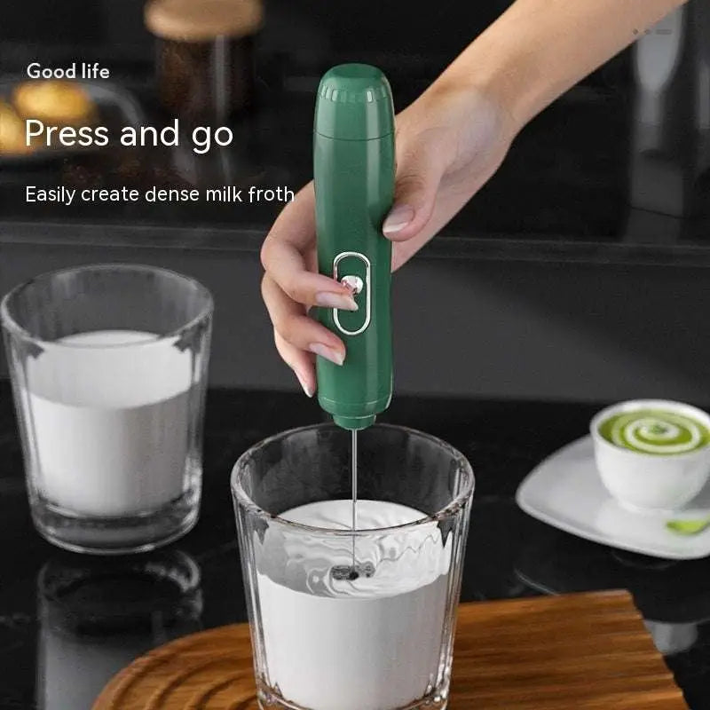 Green handheld battery version milk frother with sleek ergonomic design and silver accent button for frothing milk
