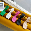 A row of five colorful minimalist square toe block heel sandals with thin straps and ankle ties in green white pink black and beige