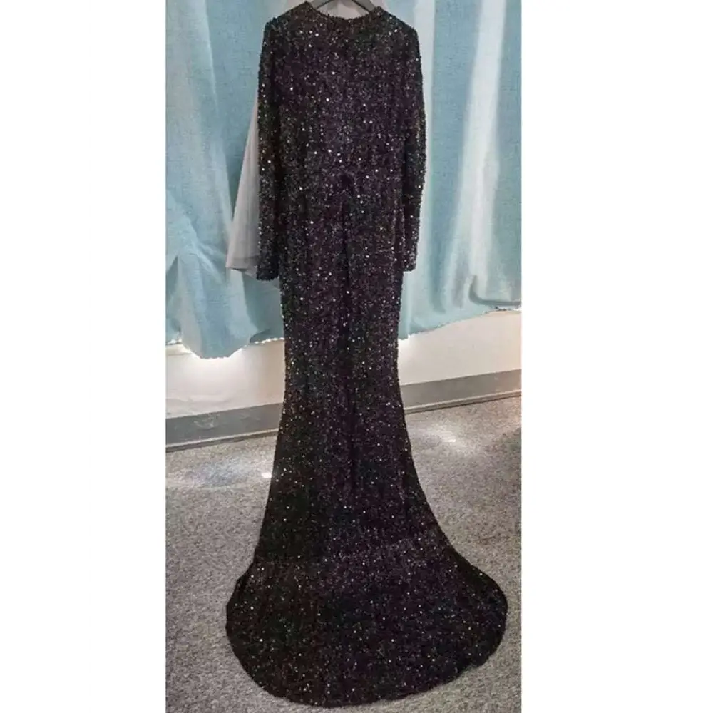 Grey long sleeve sequin mermaid evening dress with a fitted silhouette, black sequins, and sheer sleeves