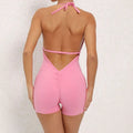Pink halter neck high elastic yoga romper featuring a v-cut neckline back tie and ruched detailing on the back side