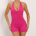 A vibrant fuchsia halter neck high yoga romper featuring a one-piece design with a deep v-cut neckline