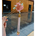 Handmade hanfu hairpin with delicate pink floral design and pink floral tassel featuring translucent gemstones and golden beads