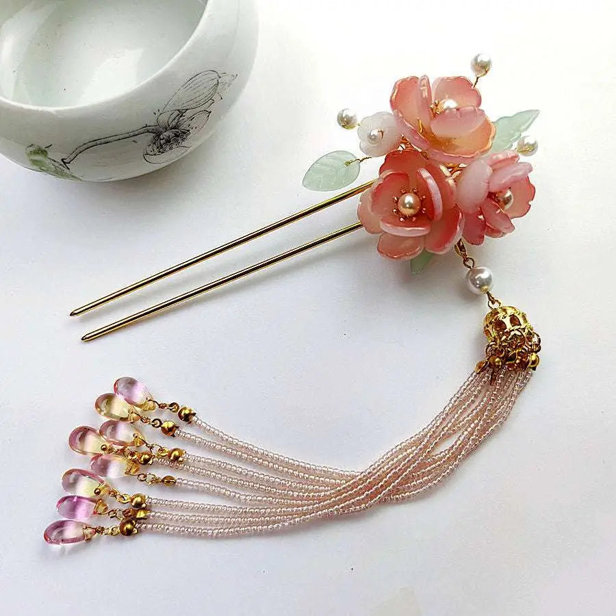 Handmade hanfu hairpin with a delicate pink floral design, gold accents, translucent gemstones, and a pink floral tassel
