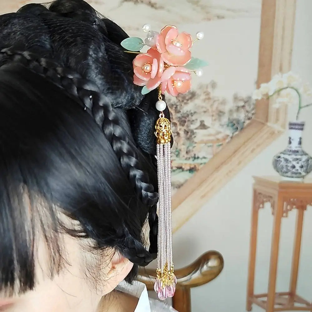 Handmade hanfu hairpin featuring a delicate pink floral design with jade leaves pearls and a pink floral tassel