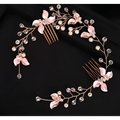 A delicate handmade leaf twisted rose gold hair comb with pink floral embellishments pearls and clear crystals