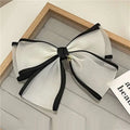 Handmade mesh bow hair clip in white and black sheer fabric with a delicate gold charm for women