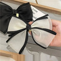 Handmade mesh bow hair clip in black and white sheer fabric with a gold-tone lock charm for women