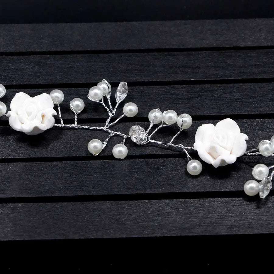 Handmade pearl white floral wedding hair chain with delicate pearls and intricate metalwork woven into braided hair
