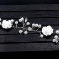 Handmade pearl white floral wedding hair chain with delicate pearls and clear crystal accents on silver wire base
