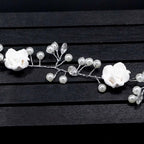 Handmade pearl white floral wedding hair chain with delicate pearls and clear crystal accents on silver wire base