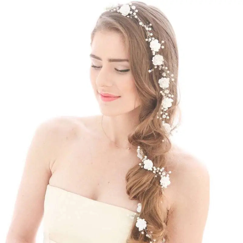 Handmade pearl white floral wedding hair chain with delicate pearls and intricate metalwork woven into braided hair