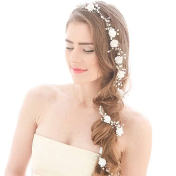 Handmade pearl white floral wedding hair chain with delicate pearls and intricate metalwork woven into braided hair