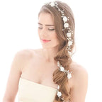 Handmade pearl white floral wedding hair chain with delicate pearls and metalwork woven into braided hair