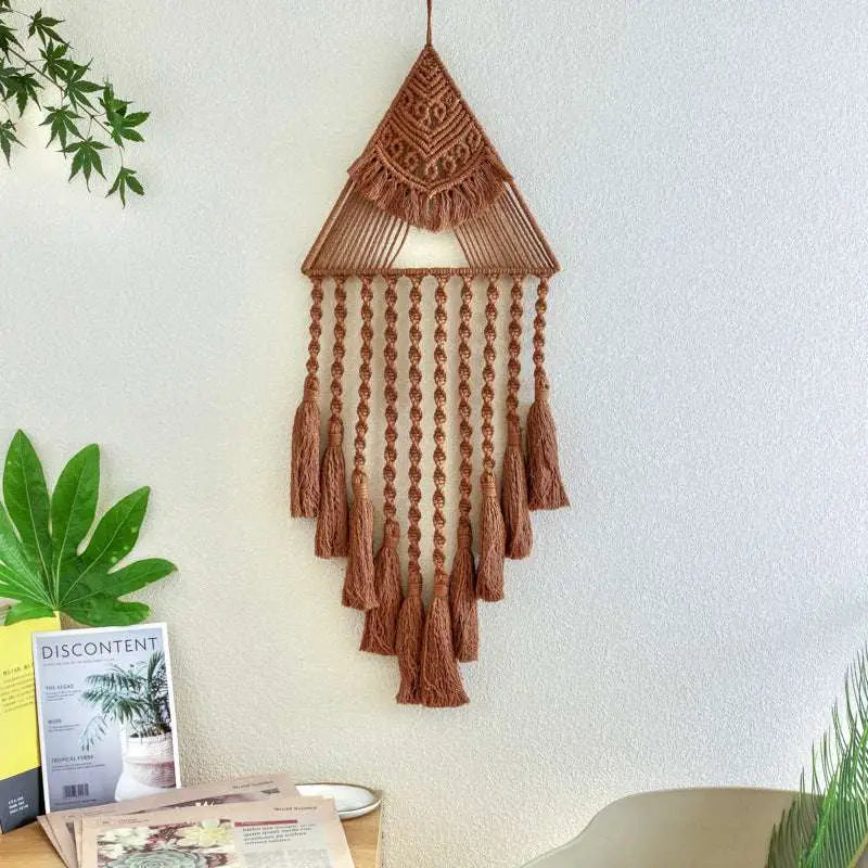A brown handwoven home decor triangle dream catcher with intricate patterns and delicate dream catcher tassels