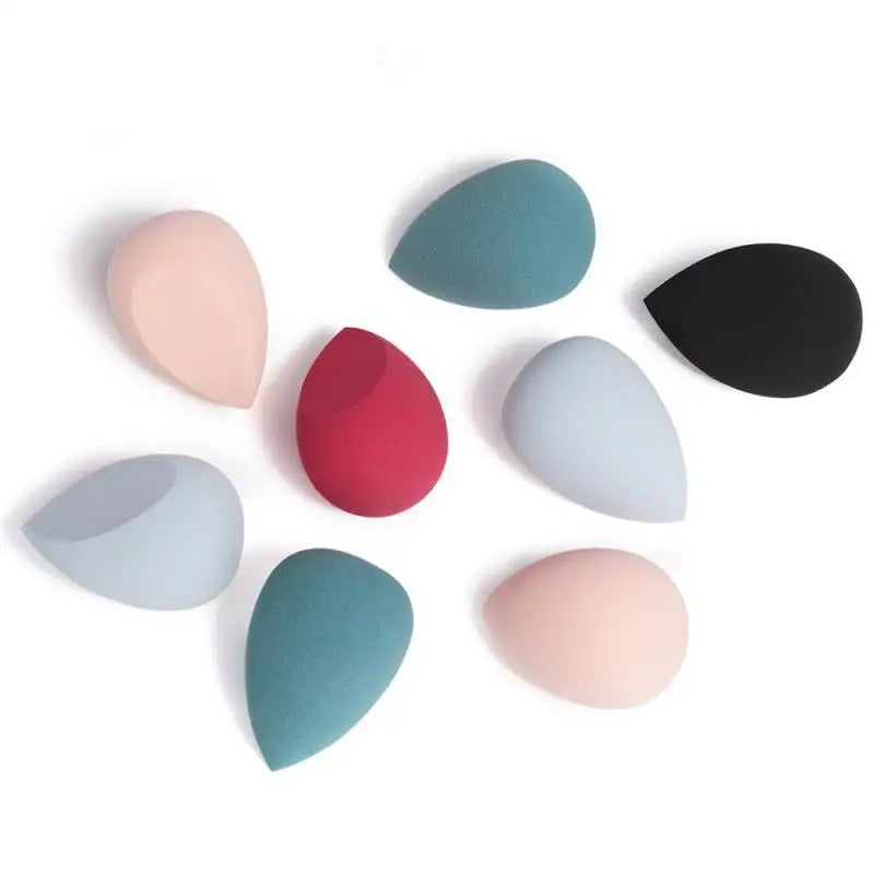 A set of pastel pink, teal, red, and black soft teardrop beauty egg makeup sponges in a heart shaped beauty gift box