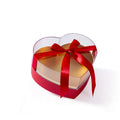 Heart shaped transparent flower packing box with clear plastic top and red satin ribbon bow for elegant gift presentation