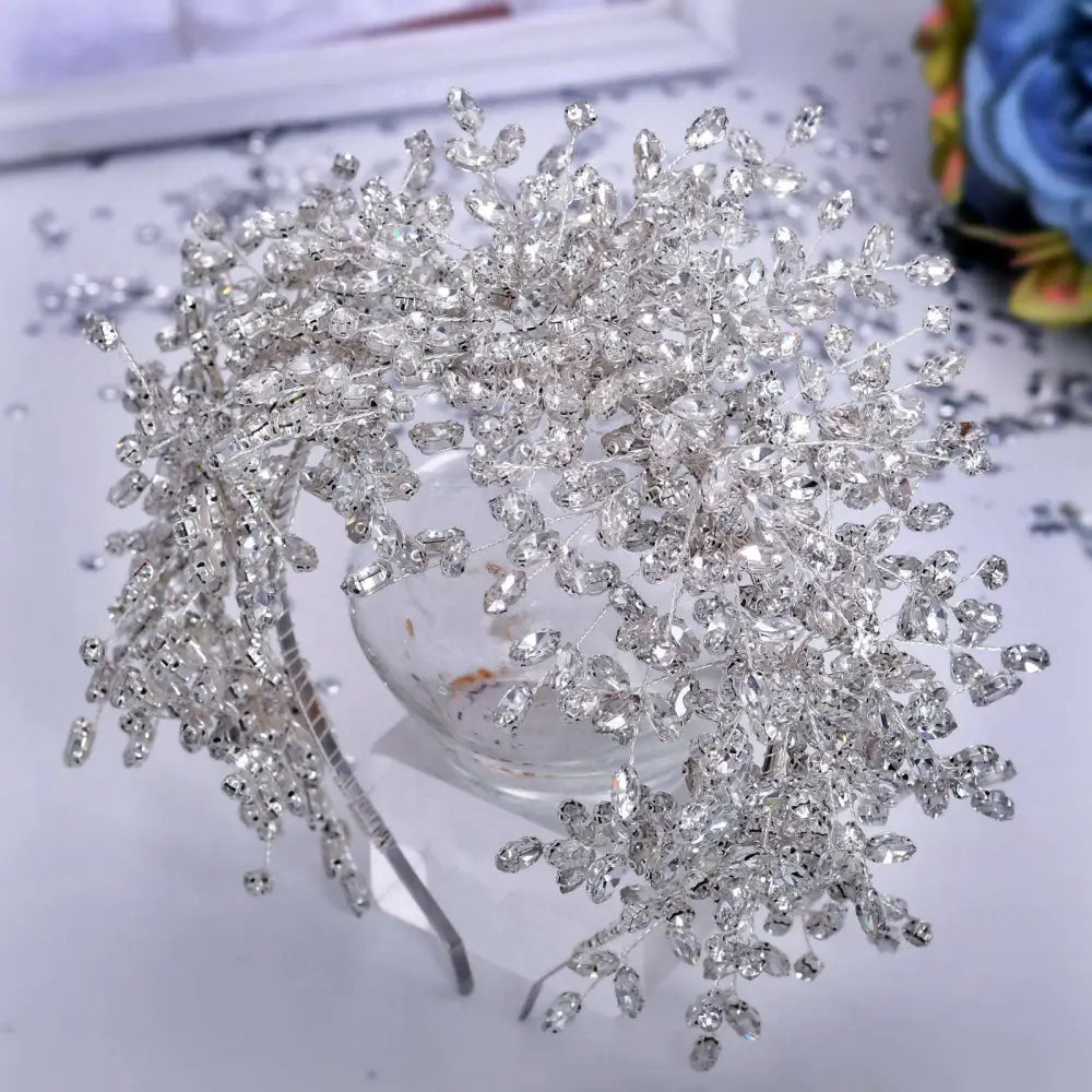 A sparkling silver crystal heavy handmade rhinestone snow queen wedding crown with intricate leaf and branch designs