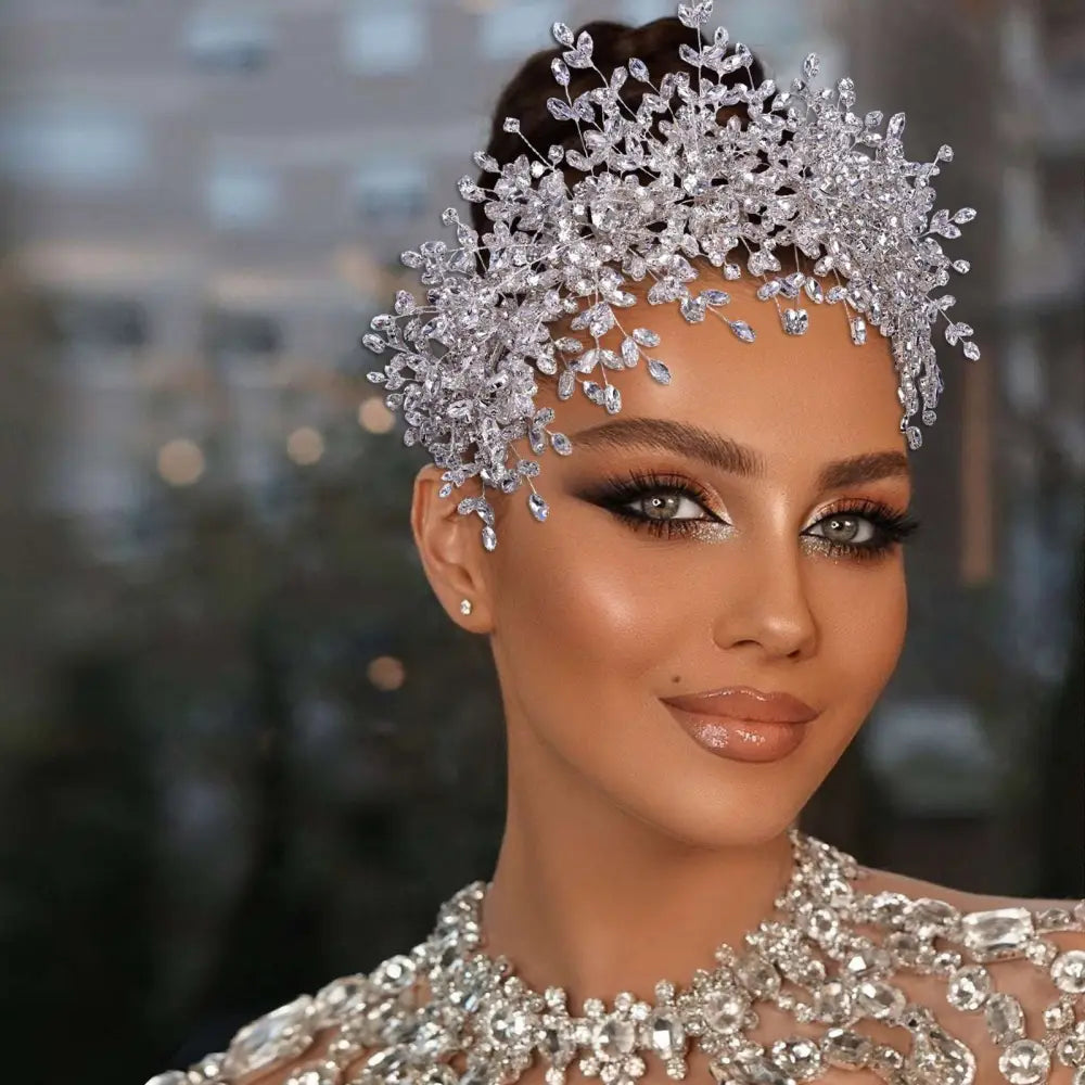 A sparkling silver crystal heavy handmade rhinestone snow queen wedding crown with intricate leaf and branch designs