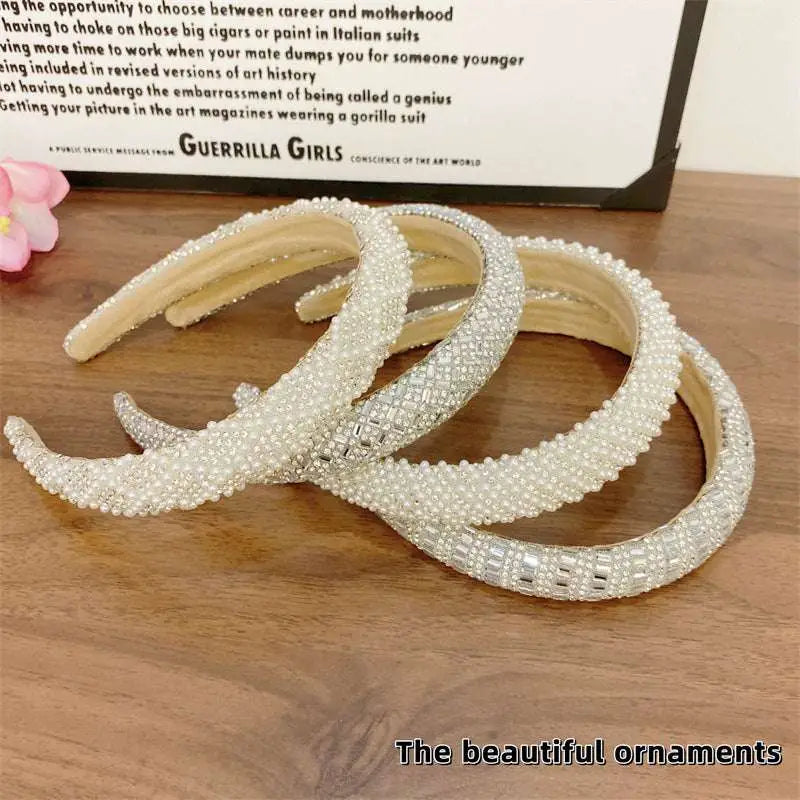 A collection of white heavy industry light luxury pearl style headbands with sparkling silver crystal embellishments