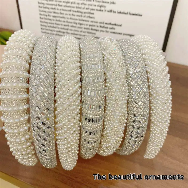 A collection of white heavy industry light luxury pearl style headbands with sparkling silver crystal embellishments