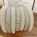 A collection of white heavy industry light luxury pearl style headbands with sparkling silver crystal embellishments
