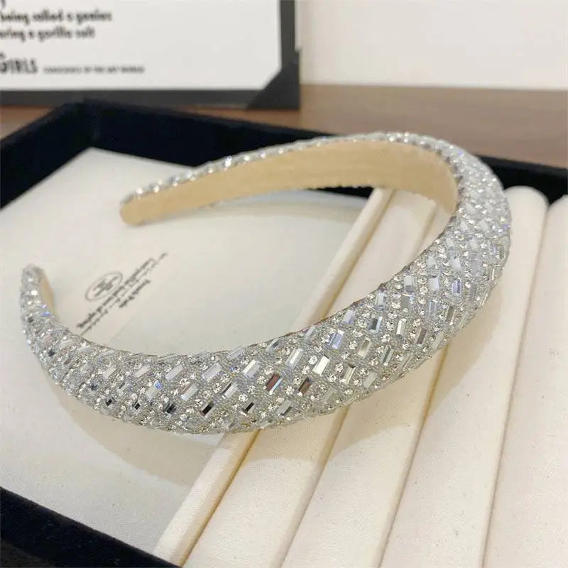 A sparkling silver heavy industry light luxury pearl style headband with wide curved design and intricate geometric patterns