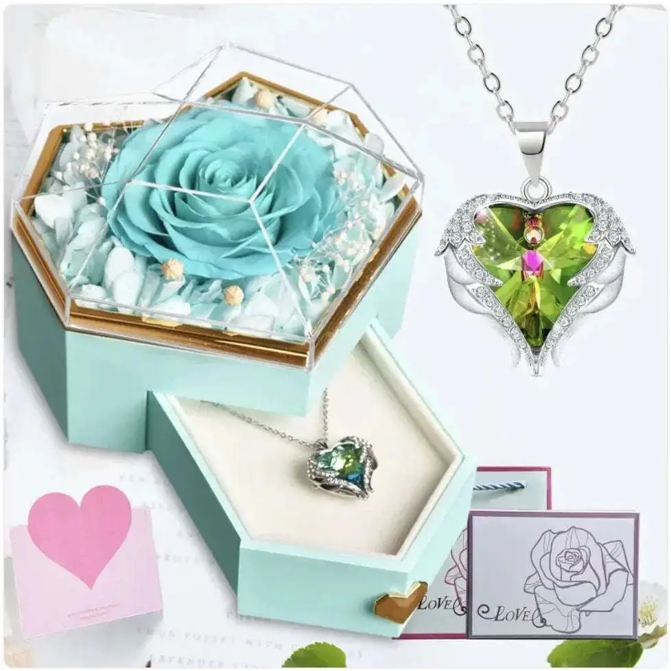 A delicate silver heart pendant necklace with green gemstone and diamond accents displayed with a hexagonal rose jewelry gift box