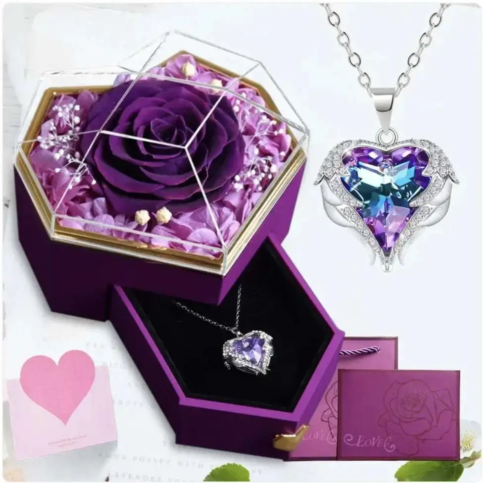 A heart-shaped pendant necklace with a purple and blue crystal in a silver setting displayed in a hexagonal rose jewelry gift box with glass top