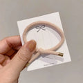 Beige braided wrist hair tie with high elasticity and gold-toned metal ends for secure hair styling