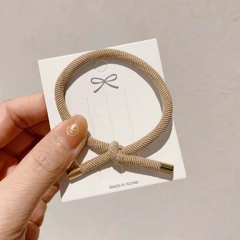 Beige braided wrist hair tie with gold-toned metal ends for secure hair styling and high elasticity use